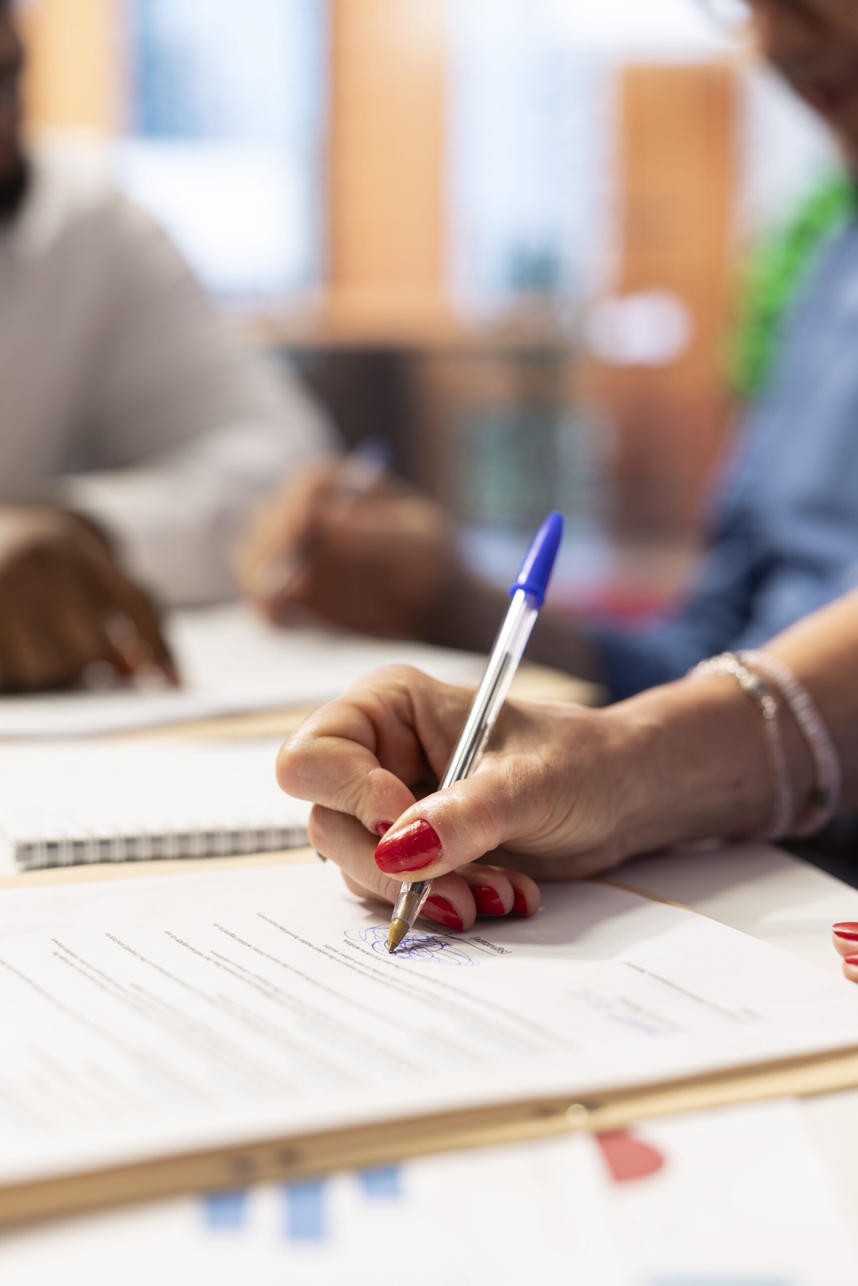 Une main en train d'écrire avec un stylo sur un papier